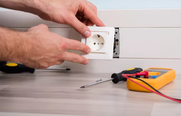Électricien installant une prise électrique moderne dans un intérieur contemporain
